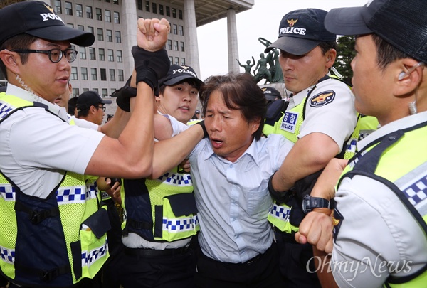 전국교직원노동조합(전교조) 조합원들이 23일 오후 국회 본청 앞에서 박근혜 정부의 노동구조개혁에 반대하는 집회를 마치고 해산하던 도중 일부가 경찰에 연행되고 있다. 전교조 조합원 50여명은 이날 "정부가 앞서 발표한 노동개혁안은 노사정위 야합의 결과물"이라며 박근혜 정권 퇴진을 요구했다.