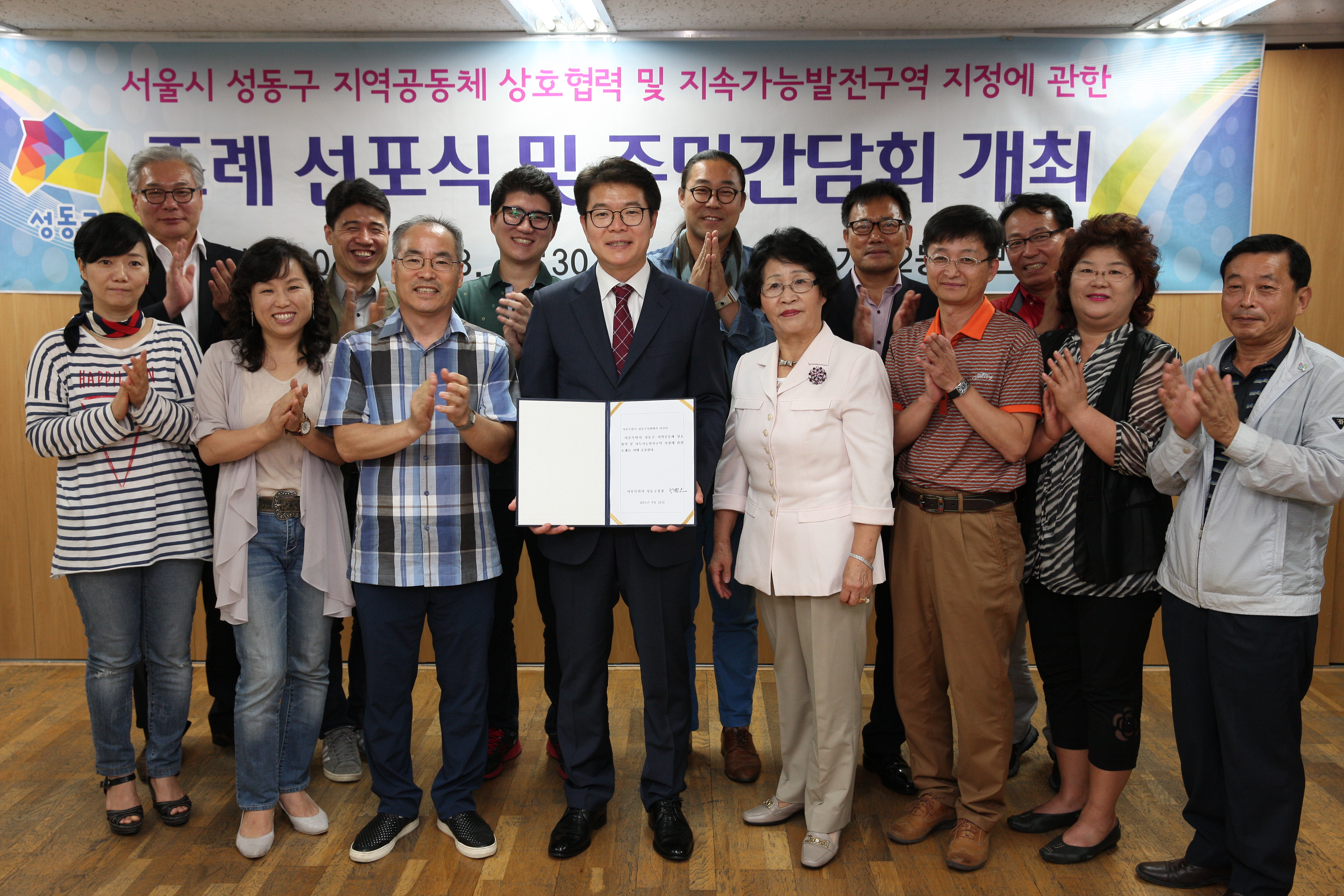전국 최초로 젠트리피케이션 방지 조례를 선포한 서울시 성동구 정원오 구청장과 주민들이 기념촬영을 하고 있다.