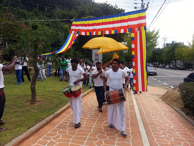 법회가 열리기 전 공양할 물건을 머리에 이고 스님과 함께 절에 들어가는 모습으로 스리랑카 전통이다.   
