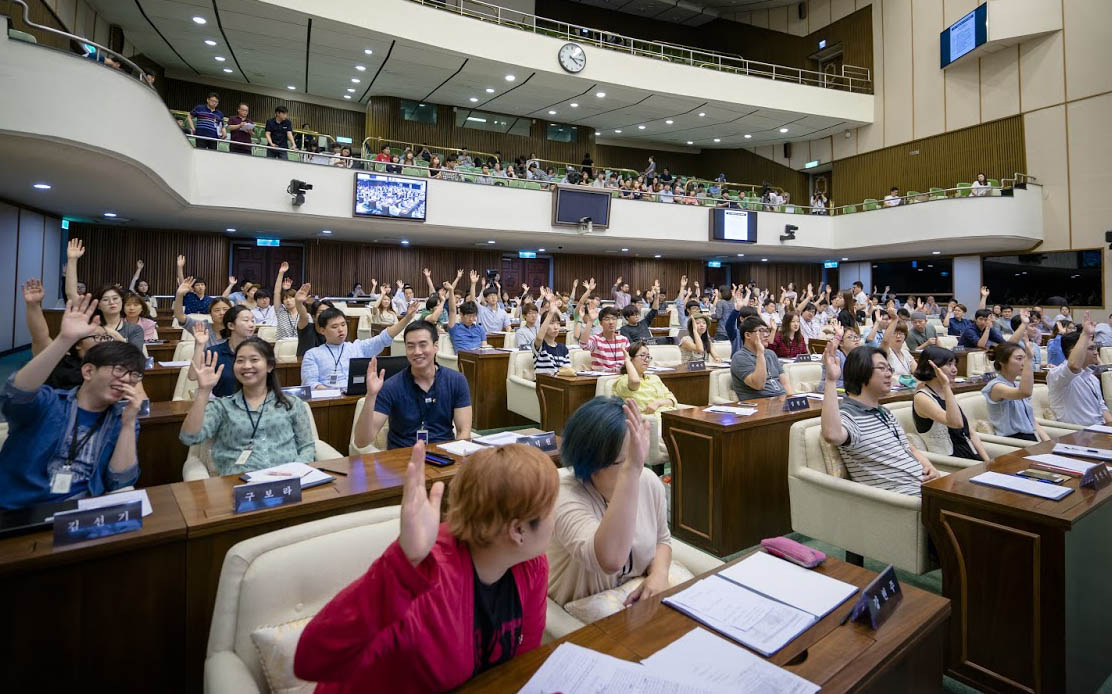 지난 2015년 7월 서울시의회 본회의장에서 열린 청년의회에서 청년의원들이 손을 들어 의사를 표현하고 있다.