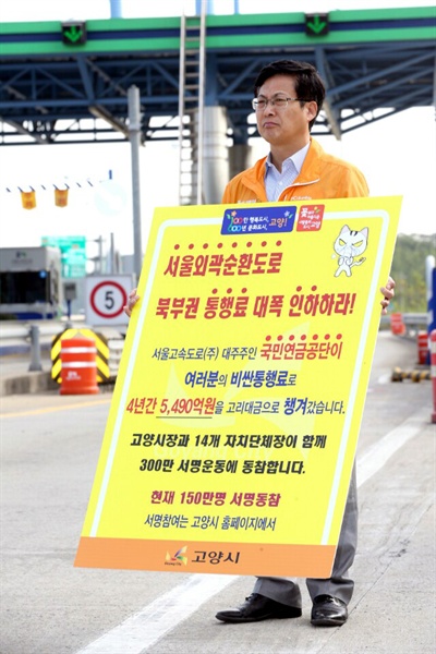 최성 고양시장이 서울외곽순환도로 통행료 인하를 요구하는 1인시위를 하고 있다.