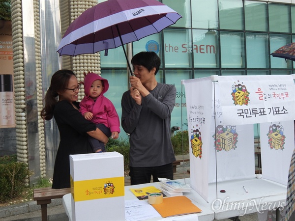 신림동 주민 한범승씨 가족은 10일 오전 박근혜 정부 노동 정책의 실상을 동네 주민들에게 알리겠다며 서울 신림역 앞에 국민 투표소를 설치하고 투표참여를 촉구했다.
