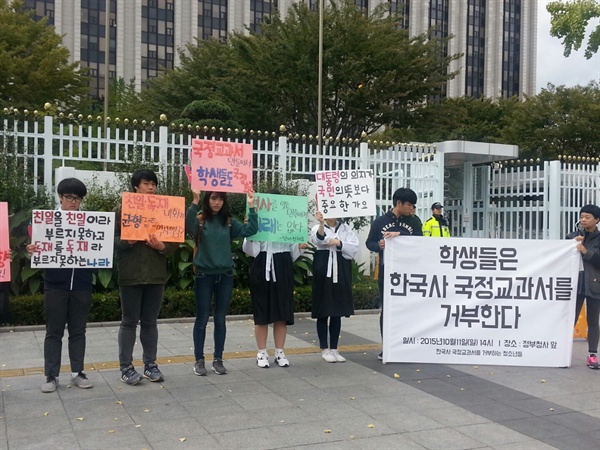 '한국사 국정교과서 거부하는 청소년 모임’ 중 한 남학생은 박정희 전 대통령을 나타내는 군복과 선글라스를 착용하고 "독재가 잘못됐다는 것은 좌 편향"이란 피켓을 들고 있다.