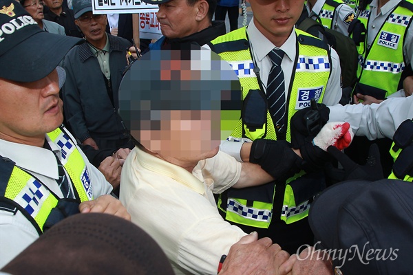 진성준 의원을 현장에서 폭행한 것으로 보이는 어버이연합 회원이 경찰에 연행되고 있다.