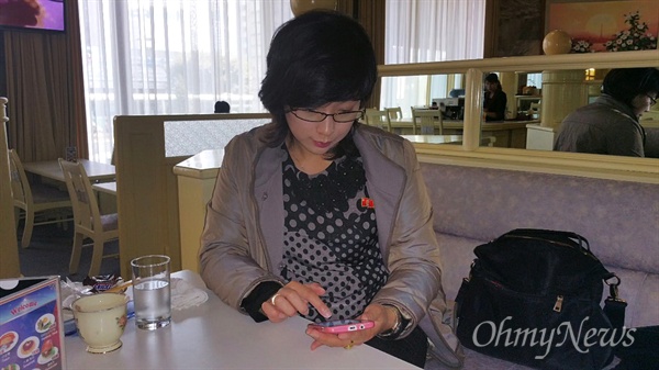 이번 북한 여행의 안내를 맡은 최경미 안내원이 북한 스마트폰인 아리랑폰을 이용하고 있는 모습.