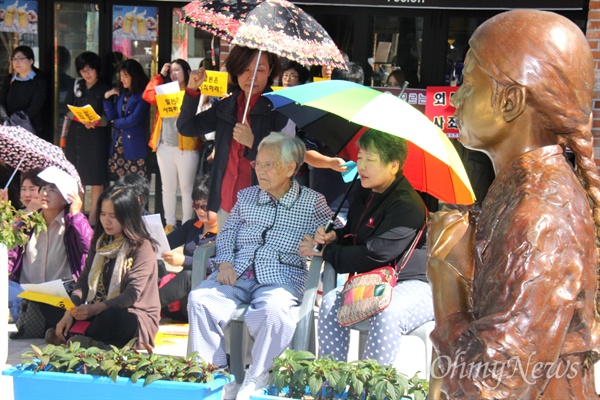 14일 낮 12시 창원 마산합포구 오동동문화광장 ‘인권자주평화 다짐비’에서 열린 '1200회 일본군 위안부 문제 해결을 위한 수요 연대시위'에서 김경애 할머니 등이 참가해 손팻말을 들고 앉아 있다.