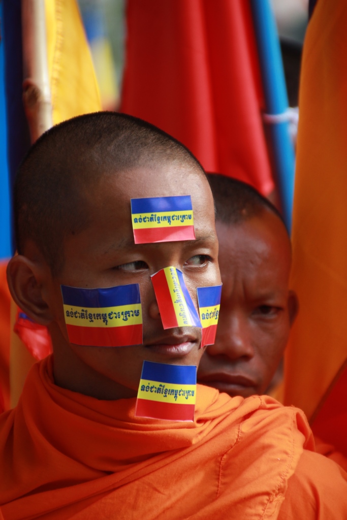 캄푸치아 크롬 깃발 스티커를 얼굴에 붙힌 채 반베트남 시위행사에 참가중인 캄보디아 승려의 모습.