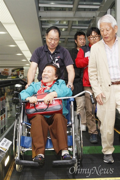 9일 나고야국제공항에 도착한 이동연 할머니가 '나고야 미쓰비시·조선여자근로정신대 소송지원회' 회원들과 공항 직원들의 도움을 받아 에스컬레이터를 오르고 있다.
