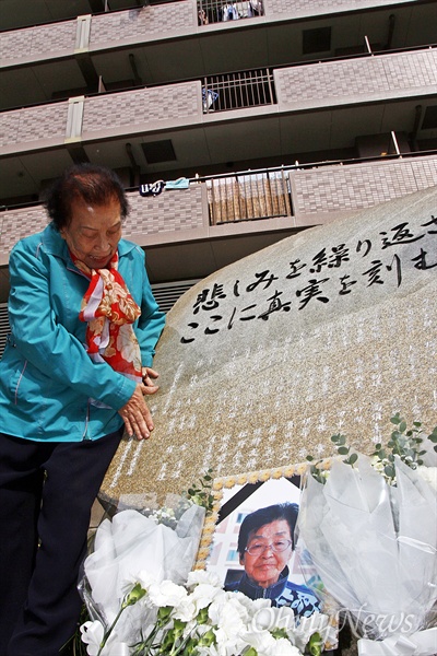 이동연 할머니가 추도비에 적힌 친구 고 최정례의 이름을 매만지고 있다. 영정 사진은 2009년 사망한 고 김혜옥 할머니.