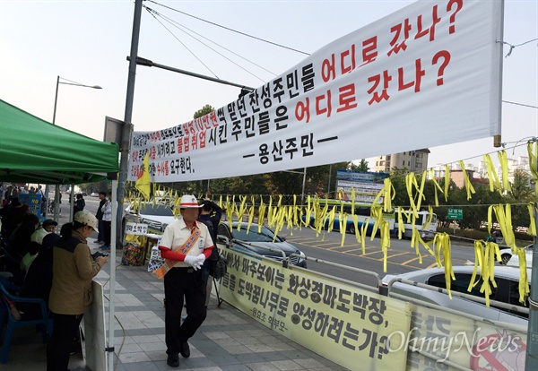  용산 화상경마장 반대 투쟁이 900일을 맞은 18일 마사회의 여론 조작 의혹을 비판하는 대형 현수막 앞으로 화상경마장 직원이 지나가고 있다. 이 현수막은 '용산화상경마도박장추방대책위'가 아닌, 찬성 집회에 동원됐던 지역 주민들이 내건 것으로 알려졌다.