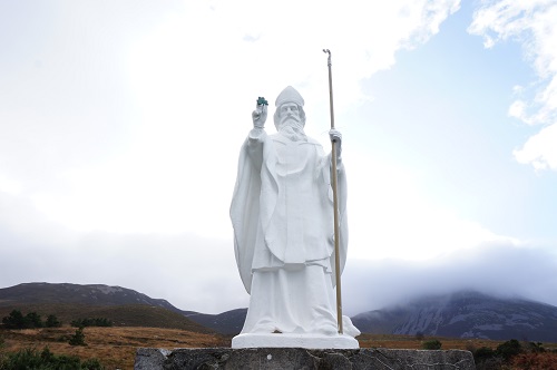 한 손에는 지팡이를, 다른 한 손에는 세잎클로버를 들고 있는 성 패트릭 신부의 동상