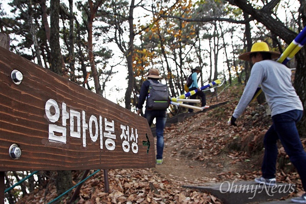 이날 국민행동과 지역의 환경단체 활동가들이 '케이블카 대신 지질공원'을 한 글자씩 적은 대형 현수막을 들고 암마이봉을 오르고 있다.