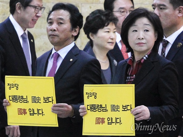 내년도 예산안 시정연설을 위해 27일 국회 본회의장으로 향하는 박근혜 대통령이 '국정교과서 반대' 피켓시위를 벌이고 있는 심상정 정의당 대표의 뒤를 지나고 있다.