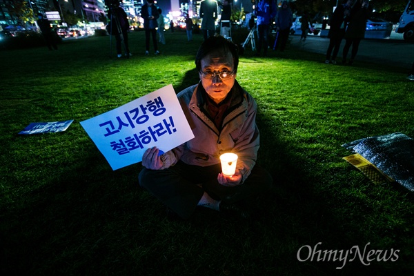 27일 오후 서울 광화문광장에서 역사교과서 국정화 반대 결의대회 및 시민사회 문화제에 참석한 한 시민이 촛불과 피켓을 들고 있다. 