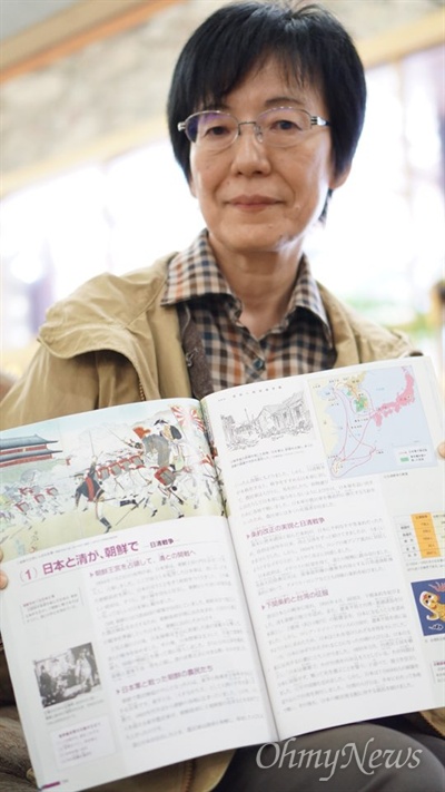 일본의 중학교 교사 구로다 다카코씨가 25일 오전 서울 용산구의 한 호텔 로비에서 자신이 쓴 일본 중학교 역사교과서인 <함께 배우는 인간의 역사>를 들고 있다. 