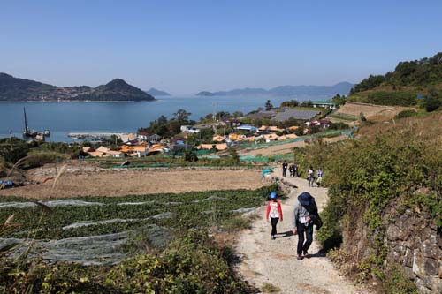 휴게정자에서 내려다 본 하화마을 풍경. 그 길을 따라 여행객들이 하늘하늘 걷고 있다.