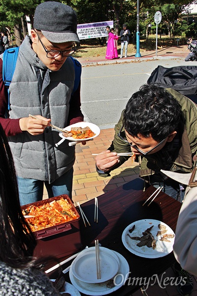 이날 분서 파티 현장을 지나던 학생들이 고기를 먹고 있다.