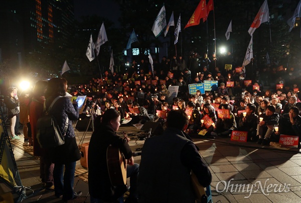 정부가 역사교과서의 국정화 확정 고시를 강행한 3일 오후 서울 중구 파이낸스센터 앞에서 열린 '한국사 교과서 국정화 강행 규탄 긴급 결의대회에 참석한 학생과 시민들이 촛불을 들어보이며 정부의 역사 교과서 국정화 철회를 촉구하고 있다.
