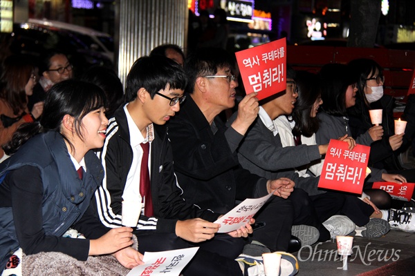'한국사교과서 국정화 반대 경남도민모임'이 4일 저녁 창원 상남동 분수광장에서 연 촛불집회에 학생들이 참석해 앉아 있다.