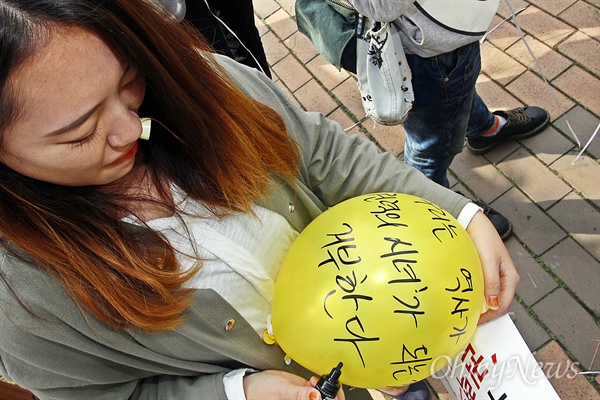 이날 기자회견에 참석한 한 학생이 역사교과서 국정화 반대 메시지를 노란 풍선에 적고 있다.