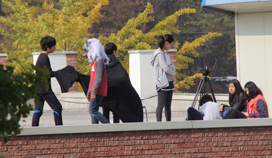 학교 건물 옥상에서 영화를 찍고 있는 6학년 학생들