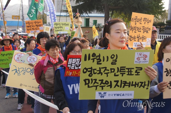 지난 10월 24일 영덕군에서 열린 원전 찬반투표 진행을 위한 거리행진에서 한 여성이 '11월 11일 영덕 주민투표로 민주주의 지켜내자'는 피켓을 들고 행진하고 있다.  