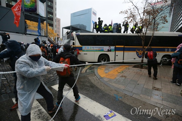 14일 오후 4시께, '11.14 민중 총궐기' 대회 참석자들이 청계광장에서 경찰 차벽에 막혀 행진이 저지되자 밧줄을 묶어 경찰버스를 끌어내고 있다.