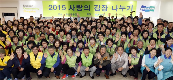  14일, 두산중공업 창원공장 사내식당에서 열린 ‘사랑의 김장 나누기’ 행사에 참여한 창원시 공무원가족봉사단, 다문화가족 다누리봉사단, 두산중공업 사회봉사단 등이 기념촬영을 하고 있다.