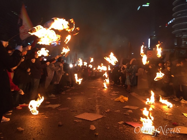 민주노총 등 53개 노동·농민·시민사회단체로 이뤄진 '민중총궐기 투쟁본부'가 14일 오후 박근혜 정부를 규탄하는 '민중총궐기 대회'를 열기 위해 광화문광장으로 향하자 경찰이 이중차벽으로 막고 나섰다. 차벽에 막힌 대회 참가자들이 '횃불 시위'를 벌이고 있다.