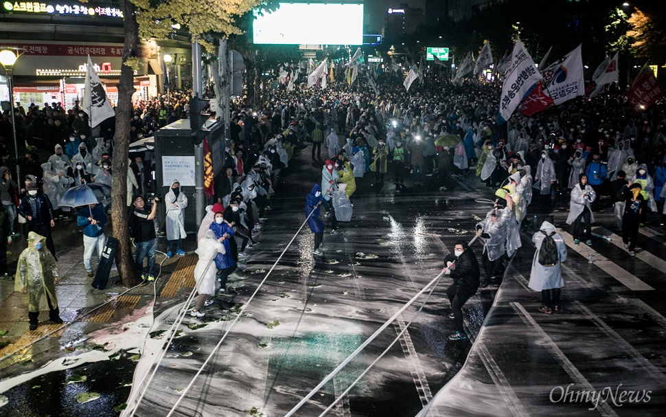 민중총궐기대회가 열린 14일 오후 서울 종로구청입구 사거리에 경찰과 대치하던 집회참가자들이 경찰 차벽을 끌어 내기 위해 밧줄로 끌어 당기고 있다.