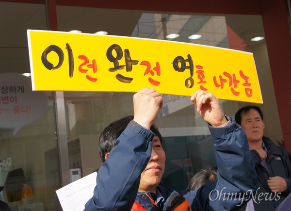 20일 오전 이완영 새누리당 국회의원 지역구 사무소 앞에서 열린 규탄 기자회견에서 한 참가자가 규탄하는 피켓을 들고 있다. 