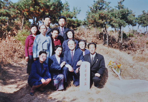 부모님 묘역을 방문했을 당시 아버님 묘지 앞에서 동생 가족들과 찍은 사진 