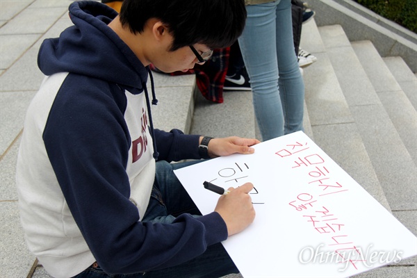 '국정 교과서 반대 경남 청소년 네트워크'가 22일 오후 창원 마산회원구 소재 국립3.15민주묘역에서 연 "박근혜 정부가 추진하는 역사 교과서 국정화 반대 청소년 행동의날"에 참가한 한 청소년이 손팻말을 만들고 있다.