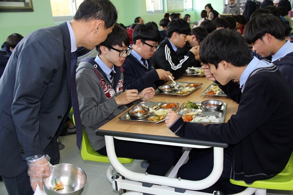 유재흥 교장(앞)이 점심시간에 학생들의 배식 활동을 돕고 있다. 
