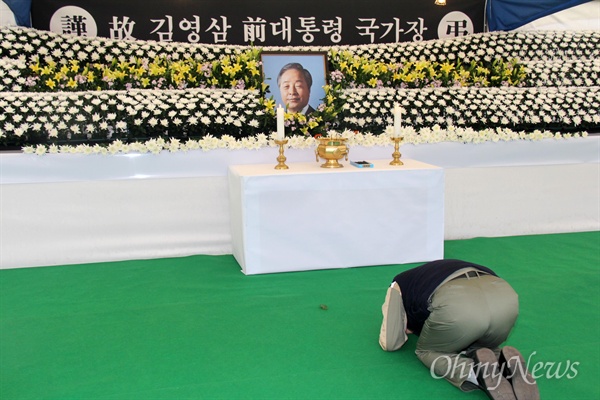 23일 경남도청 광장에 마련된 고 김영삼 전 대통령 분향소를 찾아온 한 조문객이 헌화분향한 뒤 큰절을 하고 있다.