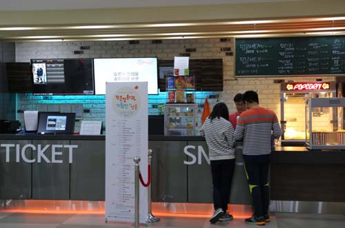 지난 15일 정남진 시네마를 찾은 관람객이 영화표에 이어 팝콘과 음료를 사고 있다. 정남진 시네마는 작은 영화관이지만, 휴식공간까지 다 갖추고 있다.