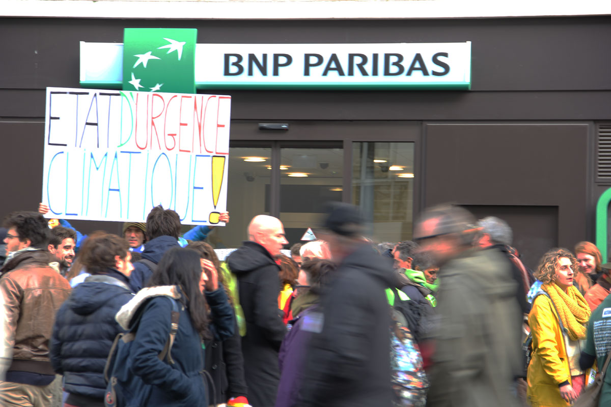 인간 띠 잇기에서 가장 많이 나온 플래카드 메시지: "국가 위기 상태는 기후변화다!" 탈세와 부정으로 꼽히는 프랑스의 3개 은행 중 하나인 BNP파리바 은행에 유난히 사람들이 많이 모여있다.