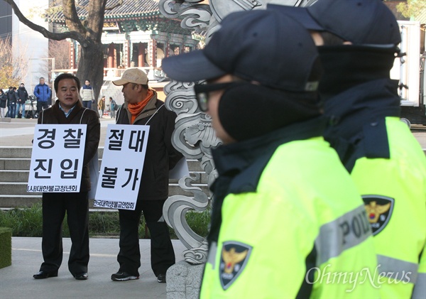 조계사 앞 "경찰 진입 절대불가"  수배중인 한상균 민주노총 위원장이 조계사에서 피신 중인 가운데 1일 오전 서울 종로구 조계사 일주문 앞에서 대한불교청년회와 한국대학생불교연합회 회원들이 경찰진입에 반대하며 '경찰진입 절대불가'라고 적힌 피켓을 들고 서 있다.