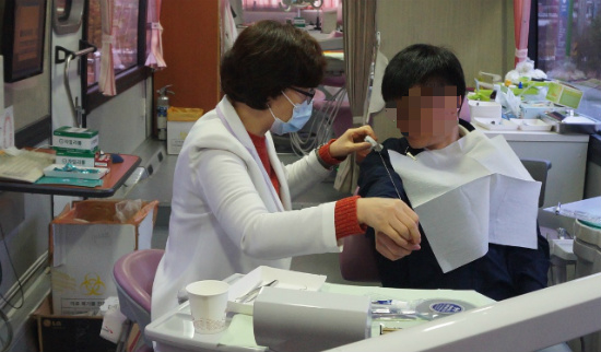 정민숙 치과위생사가 남측근로자에게 치실 사용법을 직접 실습하면서 알려주고 있다.