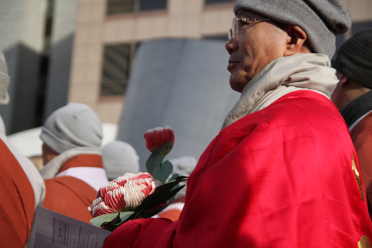 5일 광화문 한국프레스센터 앞에서 스님이 '평화의 꽃'을 들고 서 있다.