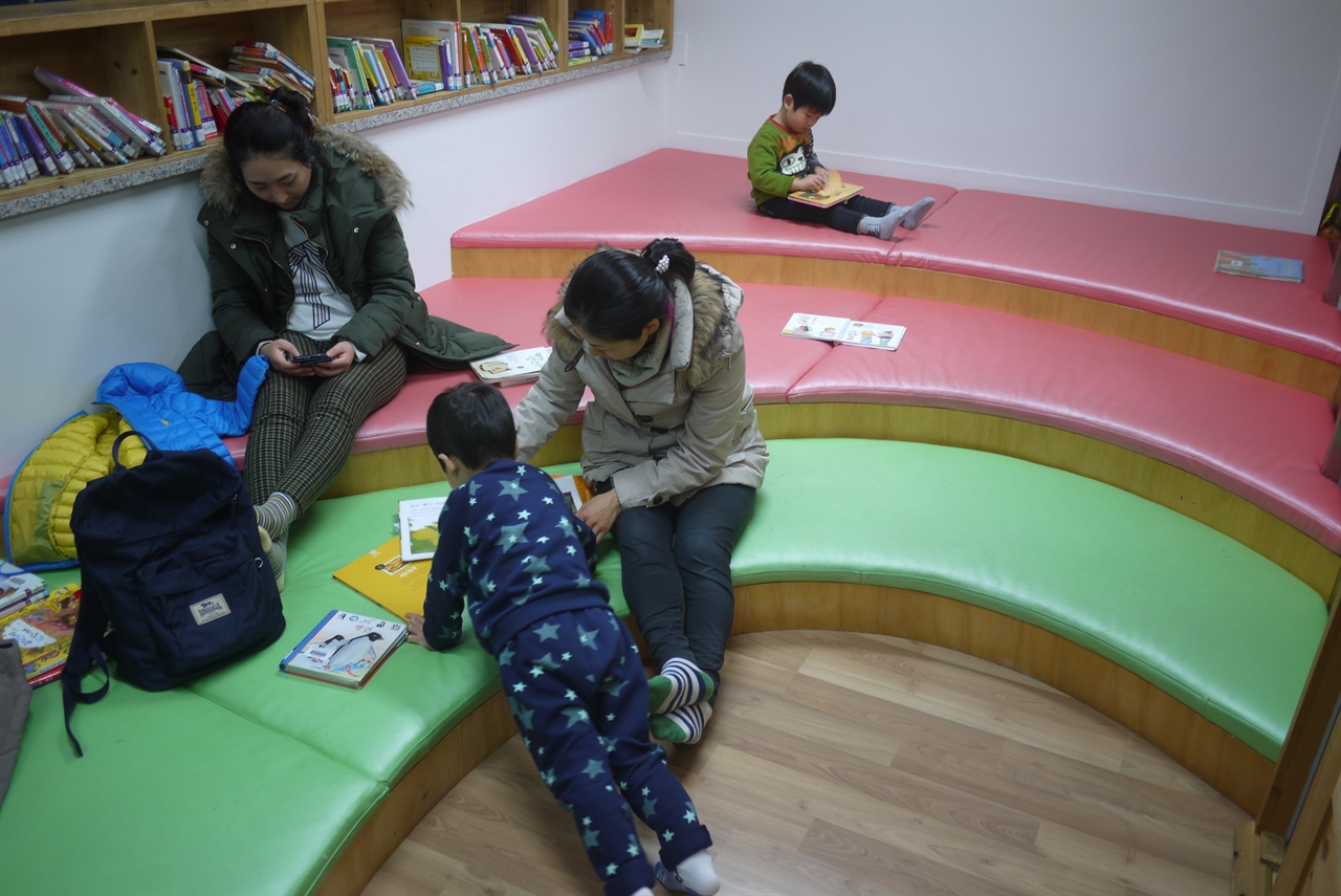 새날도서관 4층 이야기방의 모습.  어린이와 부모들이 함께 책을 읽고 있다.