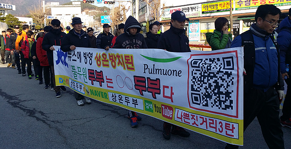 12일 오후 충북 음성군청 앞 도로에서 풀무원 사태 해결을 위한 가족대책위원회 회원들이 행진을 하고 있다.