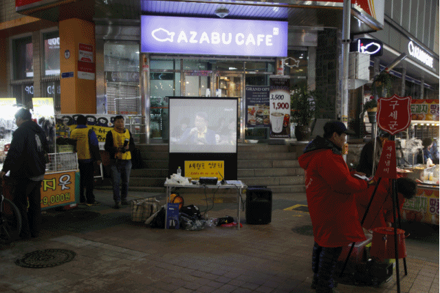 시민상주모임이 틀어 둔 <오마이TV>의 세월호 참사 특조위 청문회 영상 앞을 시민들이 지나고 있다.
