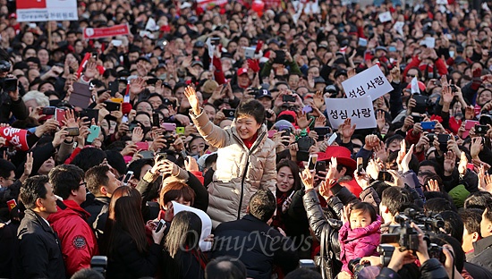 2012년 12월 15일, 박근혜 당시 새누리당 대선 후보가 서울 강남구 코엑스광장 유세에서 연설을 마친 후 환호하는 지지자들에게 손을 흔들고 있다. 