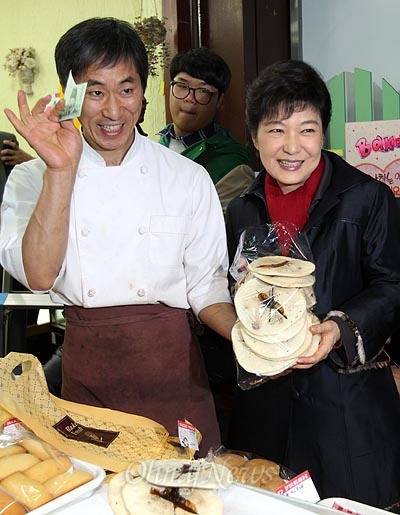 2012년 11월 16일, 박근혜 당시 새누리당 대선후보가 경남 창원 가응정시장에서 공갈빵을 구입하고 있다.
