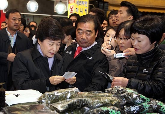 지난 2012년 11월 14일, 박근혜 당시 새누리당 대선후보가 충북 청주시 육거리종합시장에서 김, 파래 등을 구입하기 위해 전통시장 상품권인 '온누리 상품권'을 꺼내고 있다.