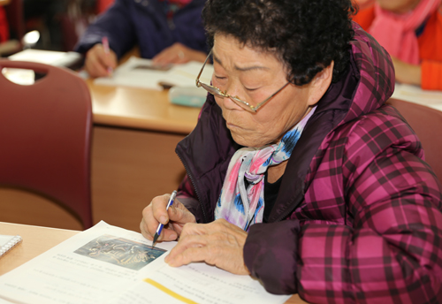 광양시노인복지관에서 진행되는 초등학력인정 문자해득과정에서 한 어르신이 안경을 쓰고 책을 보고 있다. 지난 12월 9일이다. 