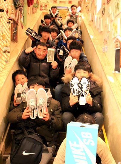 익명의 산타가 선물한 운동화를 들고 기뻐하는 박용호 경위와 소년들.