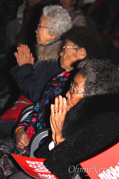 밀양765kV송전탑반대대책위가 26일 저녁 밀양 삼문동 문화체육회관에서 연 '밀양 송전탑 반대 투쟁 10주년 기념 문화제'에서 할머니들이 두 손을 모으고 공연을 지켜보고 있다.