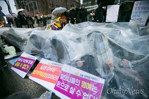  30일 오후 서울 종로구 일본대사관 앞에서 평화나비 네트워크 등 대학생들이 비를 맞으며 평화의 소녀상 주변 자리를 지키고 있다.